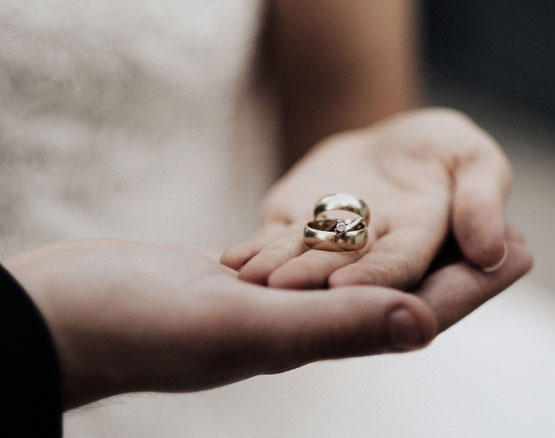 Wedding rings being held by the bride and groom