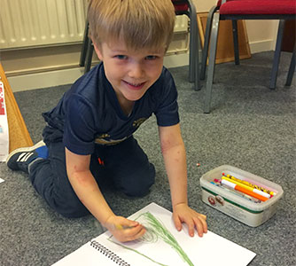 smiling child colouring in a picture
