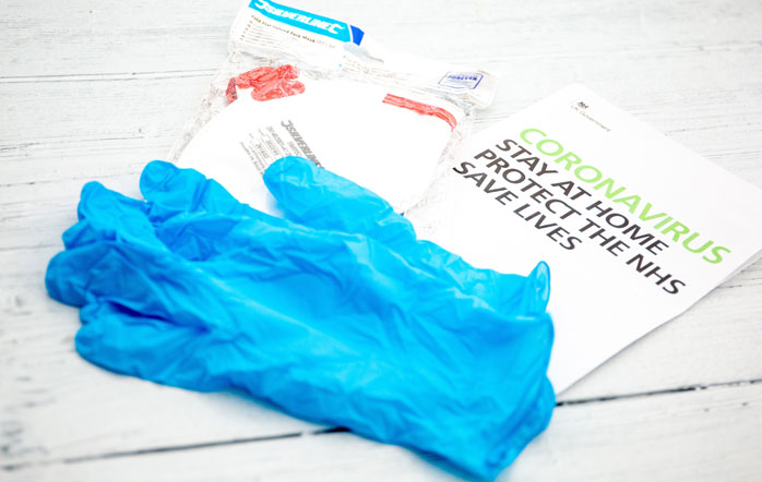 Photograph of medical gloves and COVID-19 leaflet